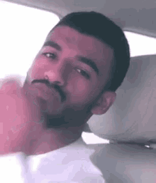 a man with a beard is sitting in the back seat of a car .