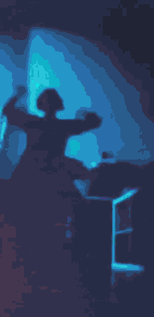 a silhouette of a person dancing in a dark room with a green background