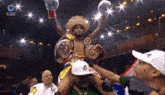 a man in a cowboy hat is being lifted in the air by a man wearing a hat that says adidas on it
