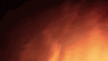 a close up of a fire with smoke coming out of it against a black background .