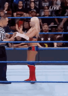 a woman is standing in a wrestling ring with a referee .