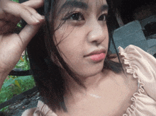 a close up of a woman 's face with a hand on her hair