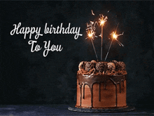 a chocolate birthday cake with sparklers on top and the words happy birthday to you below it