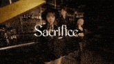 a woman in a black dress stands in front of a bar with the word sacrifice on it