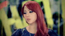 a woman with red hair is wearing a black top with feathers on the sleeves