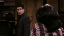 a man and a woman are talking to each other in a room .
