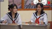 two girls in sailor uniforms are sitting at desks in a classroom with a speech bubble that says freelife
