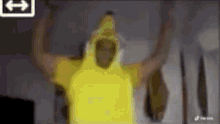 a man in a yellow banana costume is standing in front of a tv .