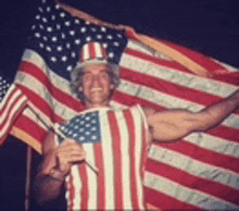 a man dressed as uncle sam is holding an american flag in his hands .