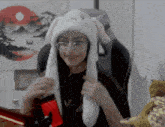 a woman wearing a white hat with bunny ears is sitting in a chair