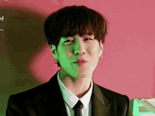 a young man is wearing a suit and tie and making a funny face .