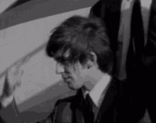 a man in a suit and tie is looking down