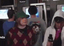 a group of people are standing in a room and one of them is wearing a sweater with diamonds on it