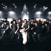 a group of people dancing in a dark room with a rocket in the background