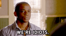 a man in a plaid shirt says we 're idiots in black text