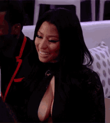 a woman in a black dress with a plunging neckline is sitting next to a man .