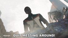 a man in a suit is standing in front of a sign that says quit messing around