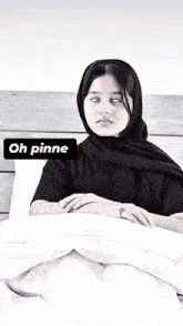 a woman in a black scarf is laying in bed with a sign that says oh pinne on it