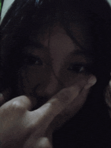 a woman is covering her face with her hand