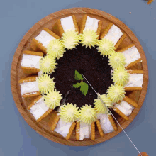 a cake with yellow frosting and cookies on a wooden tray