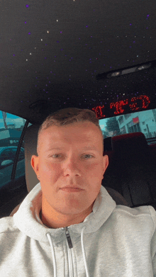 a man is sitting in a car with a sign that says it 's 2