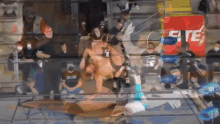 a group of people are watching a wrestling match in front of a sign that says ' eite '