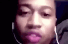 a close up of a person wearing headphones and making a face .
