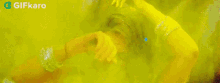 a woman is covered in yellow powder and smiling
