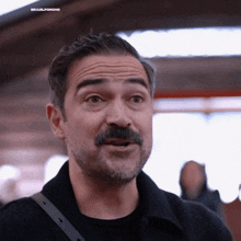 a man with a beard and mustache is wearing a black jacket with the words brazilponcho on the bottom