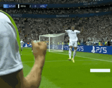 a soccer player is celebrating a goal in front of a ps5 banner