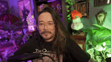 a man with long hair and glasses is wearing a shirt that says the outside