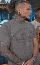 a man wearing a brooklyn 's beast t-shirt stands with his arms crossed
