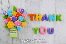 a bouquet of flowers in a vase with the words `` thank you '' written on them .