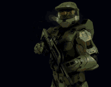 a man in a green helmet is holding a gun in his right hand