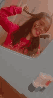 a girl is taking a selfie in front of a mirror with a cupcake on her face .