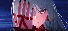 a girl with long hair and red nails covering her face with her hand