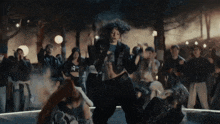 a woman in a crop top is dancing in front of a crowd of people