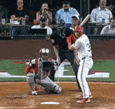 a baseball player is getting ready to hit a ball while a catcher and umpire watch .