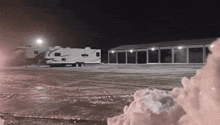 a rv is parked in a parking lot at night