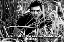 a black and white photo of a man standing in the tall grass .
