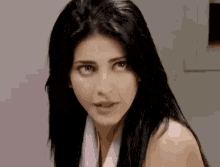 a woman with long black hair is wearing a purple scarf around her neck .