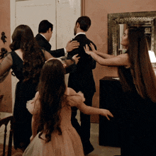a group of people standing around a man in a tuxedo