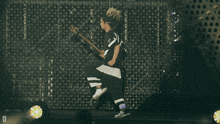a person playing a guitar with the letter v on the back of their jersey