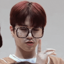 a close up of a person wearing glasses and making a funny face .