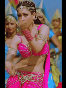 a woman in a pink top is dancing in front of other women
