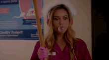 a woman blowing a bubble in front of a poster that says sperm donor