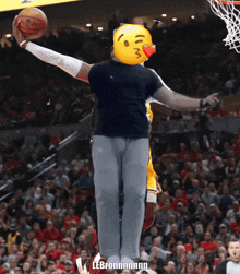 a man with a smiley face on his head holds a basketball in his hand