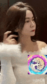 a woman in a white off the shoulder top is looking at herself in a mirror