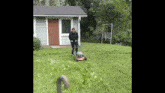 a man is mowing a lawn in front of a house .
