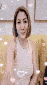 a woman in a white tank top is sitting on a couch
